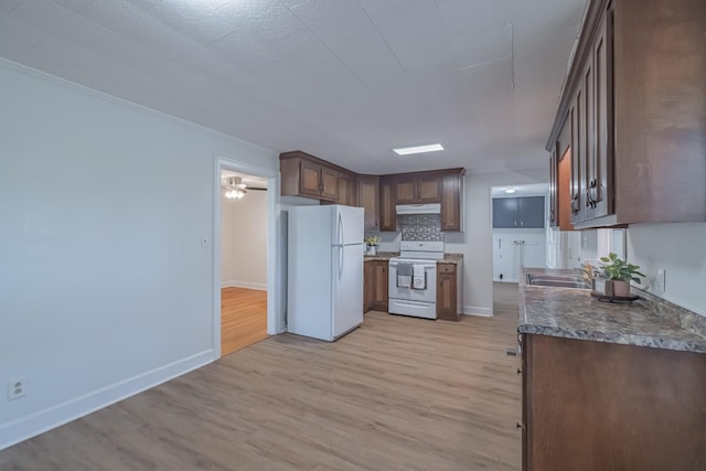 115 Highland Dr, Winchester, TN 37398 - kitchen featuring under cabinet range hood, light wood-type flooring, a sink, and white appliances
