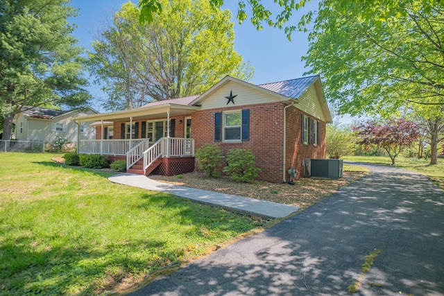 115 Highland Dr, Winchester, TN 37398 - view of front of house with a front lawn, central AC, driveway, covered porch, and brick siding