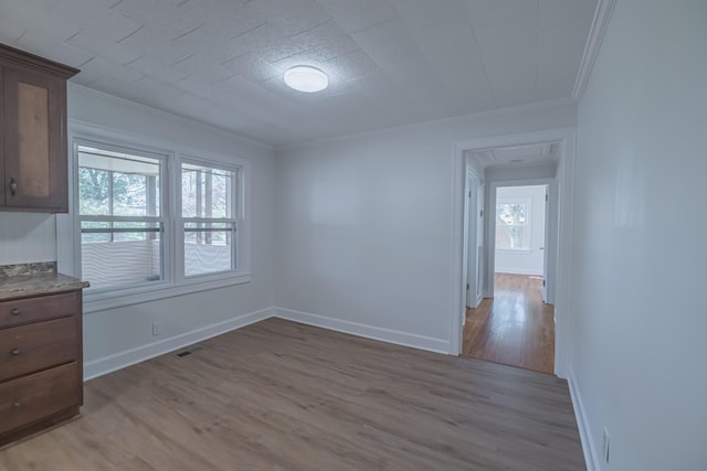 115 Highland Dr, Winchester, TN 37398 - unfurnished dining area featuring light wood-type flooring, visible vents, ornamental molding, and plenty of natural light