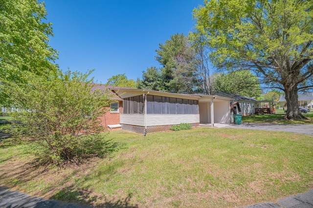 115 Highland Dr, Winchester, TN 37398 - exterior space with a front lawn, driveway, board and batten siding, an attached carport, and a sunroom