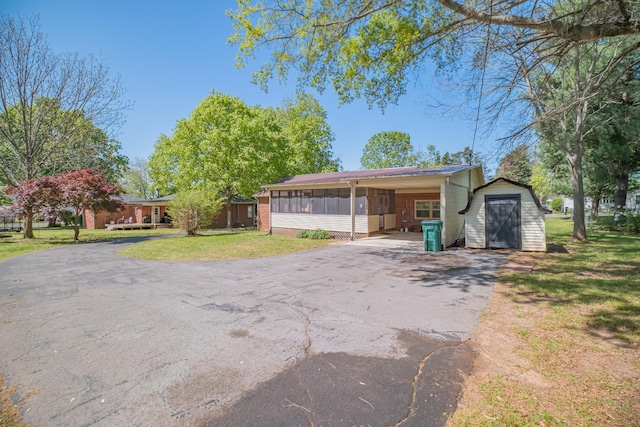 115 Highland Dr, Winchester, TN 37398 - view of front of property with a storage shed, an outdoor structure, driveway, a sunroom, and a front yard