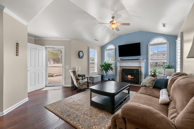 living room with baseboards, a ceiling fan, dark wood finished floors, a lit fireplace, and lofted ceiling