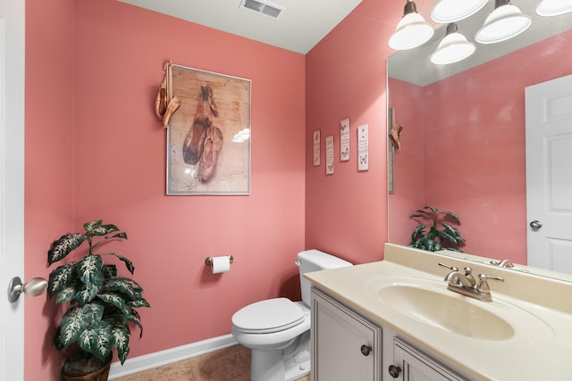 bathroom featuring visible vents, baseboards, toilet, vanity, and tile patterned flooring