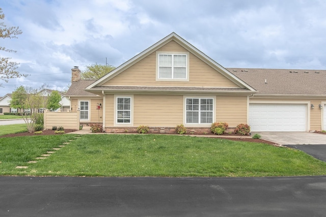 view of front of property featuring a chimney, aphalt driveway, a garage, and a front lawn