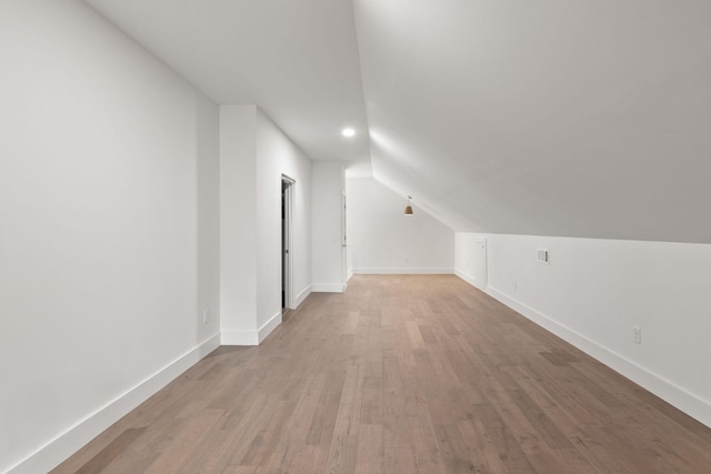 additional living space featuring recessed lighting, baseboards, wood finished floors, and vaulted ceiling