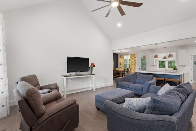 living area with recessed lighting, high vaulted ceiling, wood finished floors, and a ceiling fan