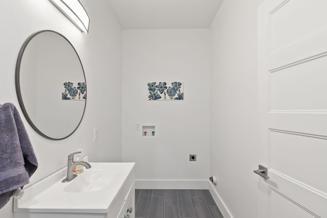 interior space with baseboards, washer hookup, a sink, cabinet space, and electric dryer hookup