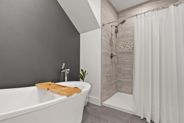 full bath featuring a tile shower and a freestanding bath