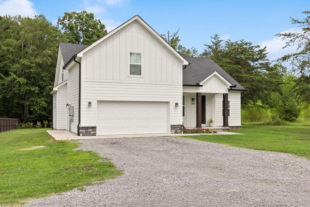 modern inspired farmhouse with an attached garage, board and batten siding, a front lawn, driveway, and roof with shingles