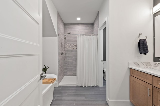 bathroom featuring a freestanding tub, toilet, a shower stall, recessed lighting, and vanity