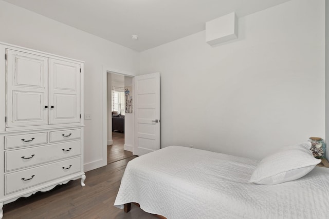 bedroom with dark wood-type flooring and baseboards
