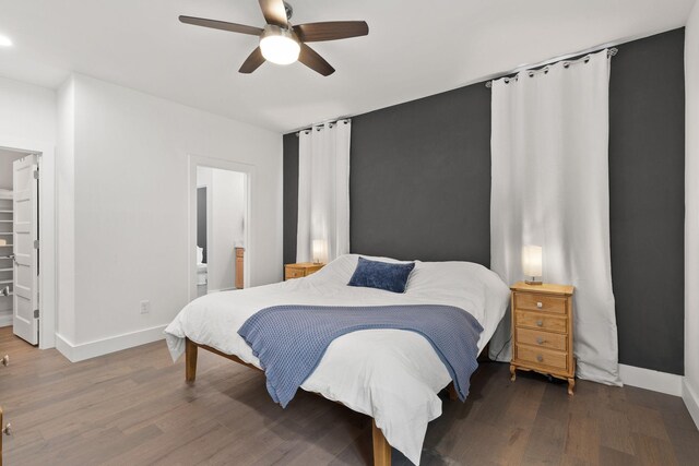 bedroom featuring wood finished floors, baseboards, a closet, and a walk in closet