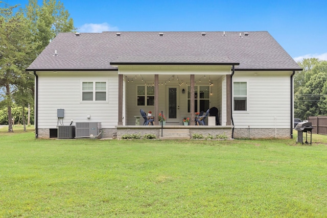 back of house featuring roof with shingles, a patio, a lawn, and central air condition unit