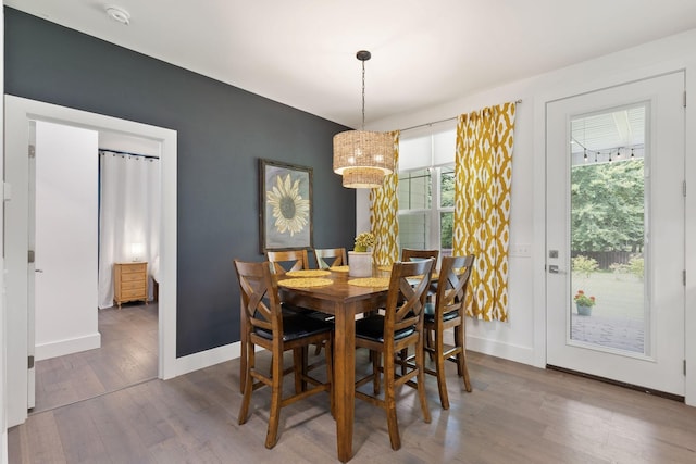 dining space with baseboards and wood finished floors