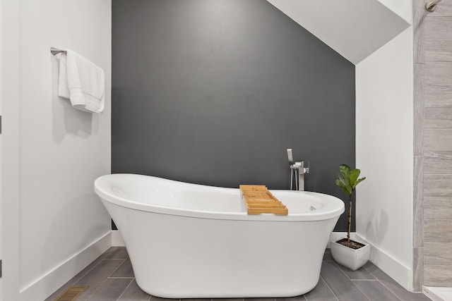 full bath with tile patterned floors, a soaking tub, and baseboards