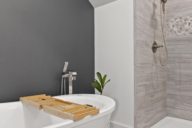 bathroom with a sink and a tile shower