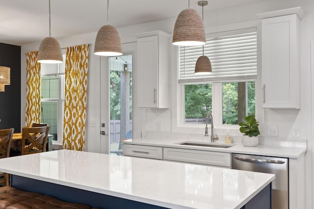 kitchen with decorative light fixtures, dishwasher, white cabinetry, and a sink