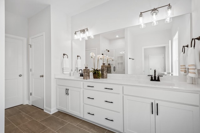 full bathroom with double vanity, a shower stall, tile patterned floors, and a sink