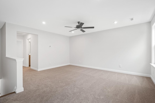 unfurnished room with baseboards, visible vents, a ceiling fan, and light colored carpet