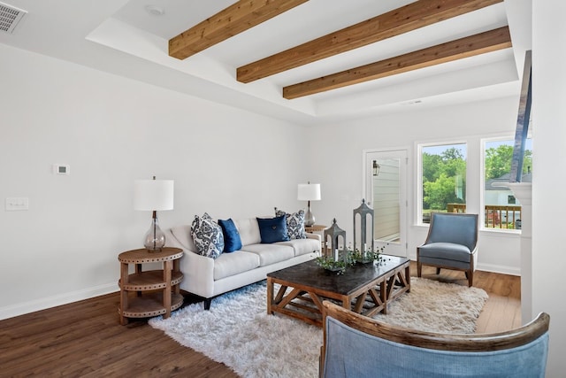 living area featuring beamed ceiling, wood finished floors, visible vents, and baseboards