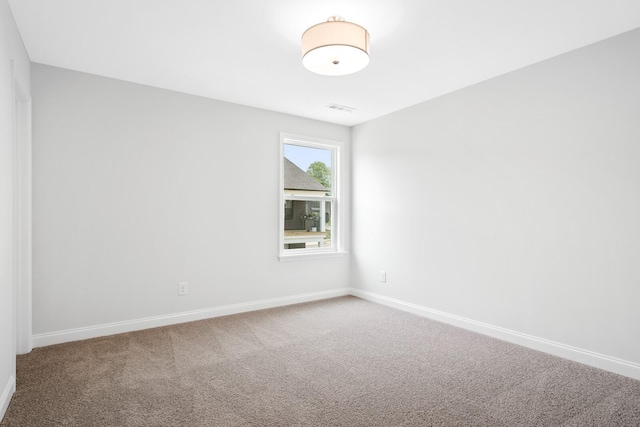 carpeted empty room featuring visible vents and baseboards