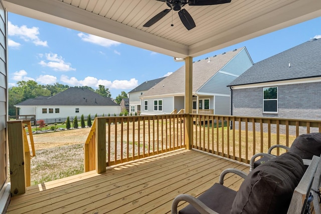 wooden deck with a residential view, a lawn, a fenced backyard, and ceiling fan