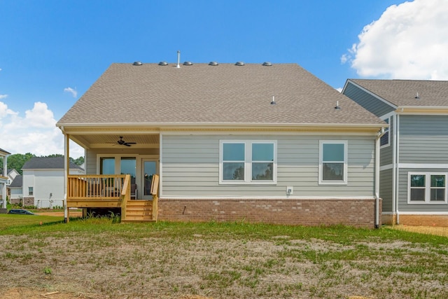 back of house featuring a lawn, a deck, a shingled roof, brick siding, and ceiling fan