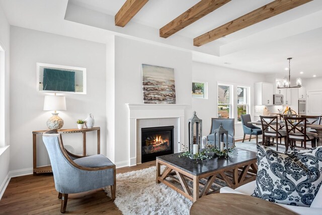 living room featuring baseboards, recessed lighting, beamed ceiling, wood finished floors, and a fireplace