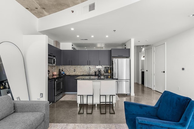 kitchen featuring visible vents, open floor plan, dark countertops, stainless steel appliances, and backsplash