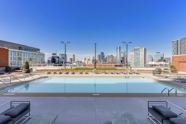 community pool with a view of city and a patio area