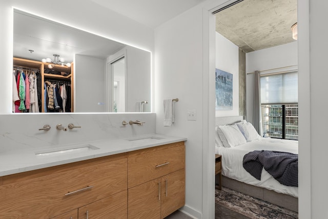 ensuite bathroom with a sink, ensuite bathroom, double vanity, and a walk in closet