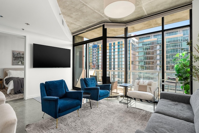 living room with a wall of windows and finished concrete floors