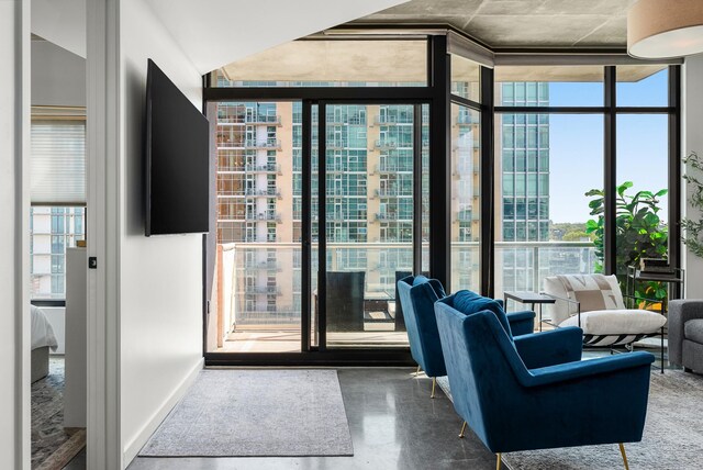 interior space featuring concrete floors, baseboards, and floor to ceiling windows