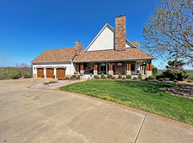 110 Giles Ln, Gallatin, TN 37066 - view of front of home with a front yard, covered porch, a garage, a chimney, and concrete driveway