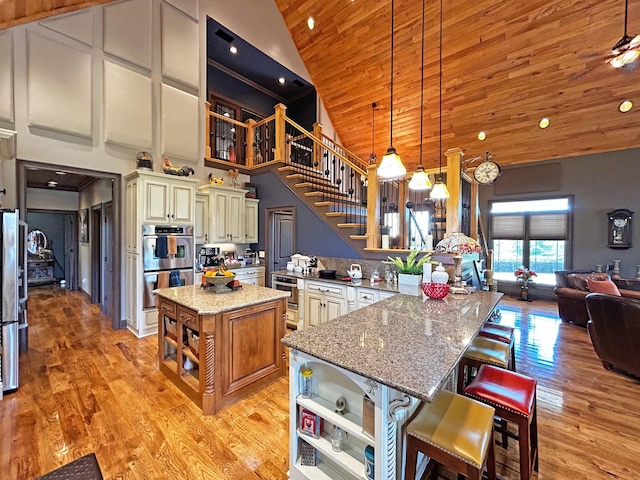 110 Giles Ln, Gallatin, TN 37066 - kitchen with cream cabinets, open shelves, light stone countertops, high vaulted ceiling, and double oven