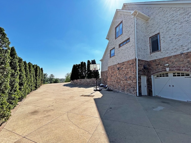 110 Giles Ln, Gallatin, TN 37066 - view of side of property with a garage, stone siding, and concrete driveway
