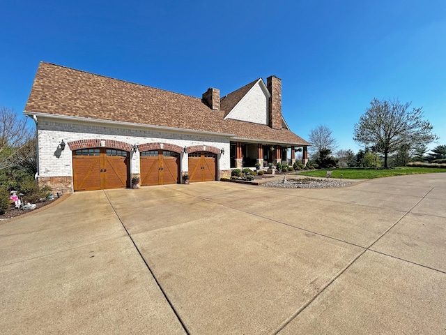 110 Giles Ln, Gallatin, TN 37066 - view of side of property featuring a garage, driveway, a chimney, and a shingled roof