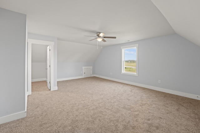 bonus room featuring ceiling fan, light colored carpet, baseboards, and lofted ceiling