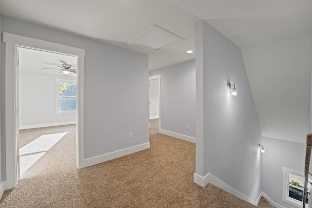 interior space with carpet floors, baseboards, and attic access
