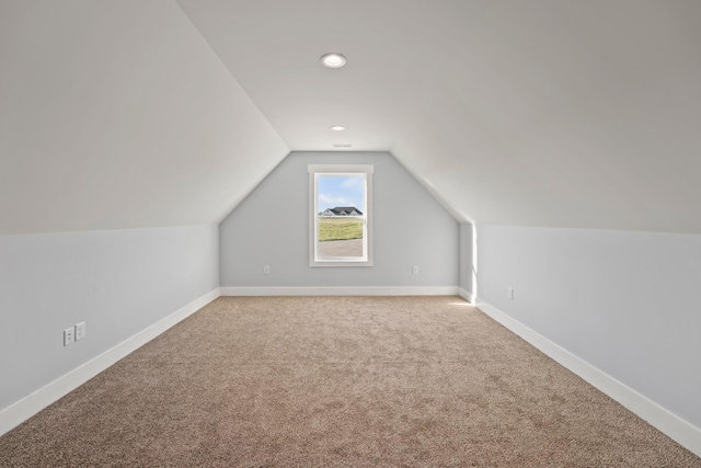 additional living space featuring baseboards, carpet, and vaulted ceiling