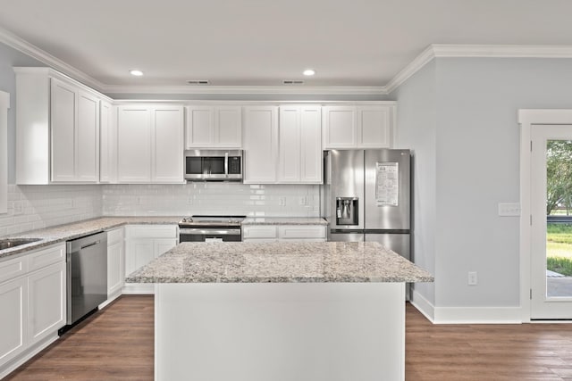 kitchen with crown molding, white cabinetry, and stainless steel appliances
