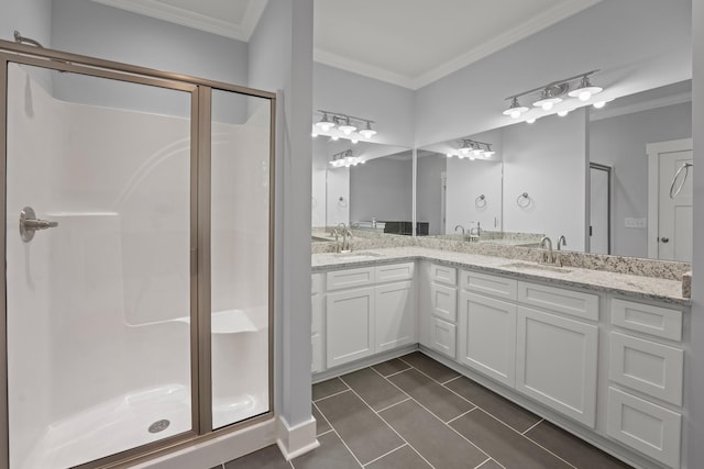 bathroom with a sink, ornamental molding, tile patterned floors, and a stall shower