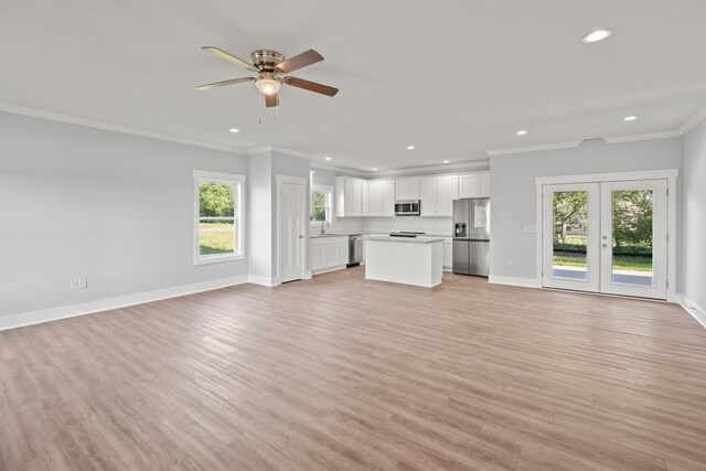 unfurnished living room featuring recessed lighting, light wood finished floors, ornamental molding, and a ceiling fan