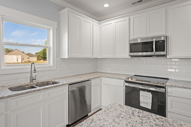 kitchen with tasteful backsplash, visible vents, a sink, appliances with stainless steel finishes, and white cabinetry