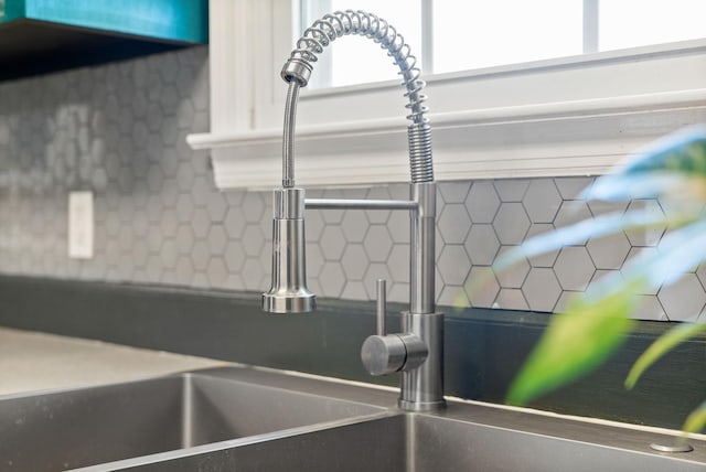 details featuring a sink and decorative backsplash