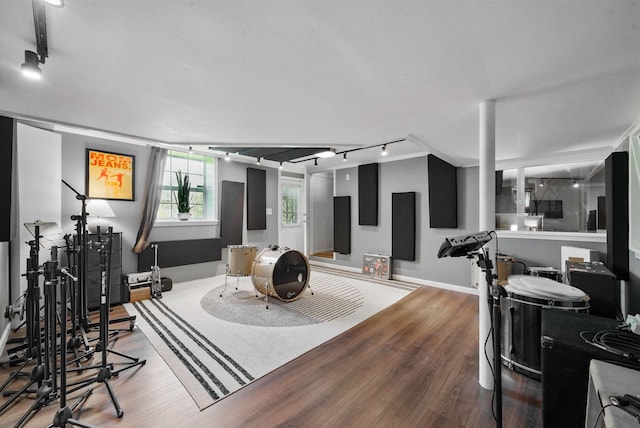 living area featuring baseboards, rail lighting, and wood finished floors