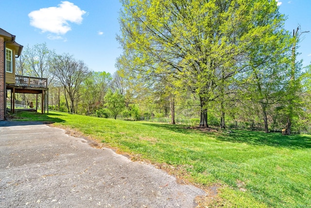 view of yard with driveway and a wooden deck