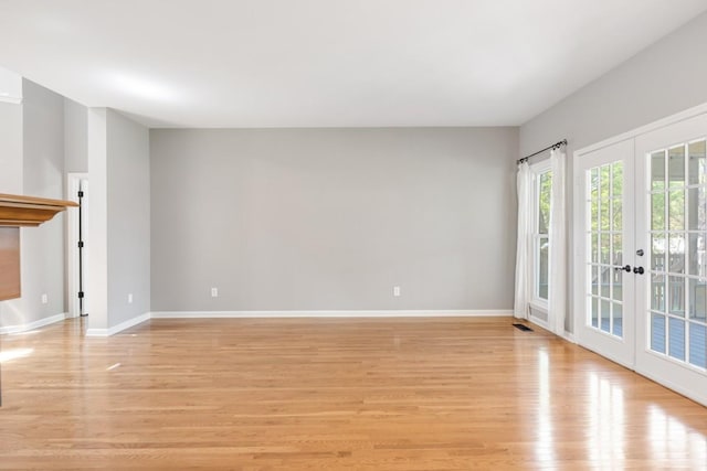unfurnished living room with visible vents, french doors, baseboards, and light wood-style floors