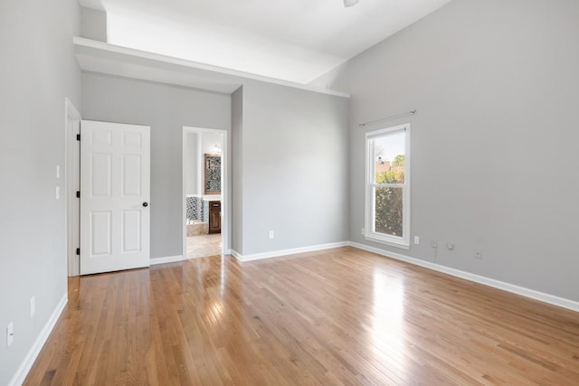 spare room with baseboards and light wood-style floors