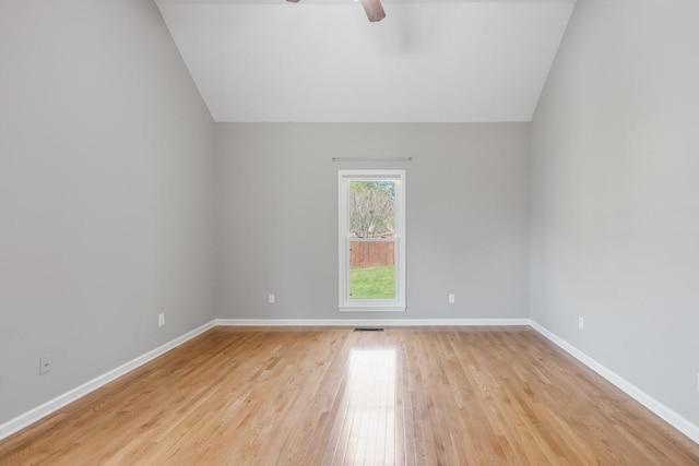 unfurnished room featuring baseboards, vaulted ceiling, ceiling fan, and light wood-type flooring